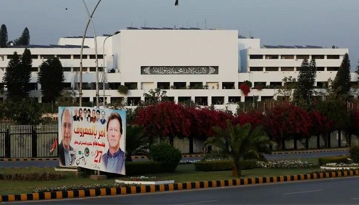 A campaign poster featuring Pakistani Prime Minister Imran Khan is seen with the parliament building in the background, in Islamabad, Pakistan, 2 April, 2022 || Photo: Reuters