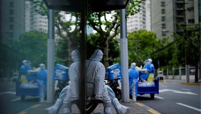 A worker in a protective suit keeps watch at a bus station during lockdown, amid the coronavirus disease (Covid-19) pandemic, in Shanghai, China, April 30, 2022 || Reuters Photo: Collected 