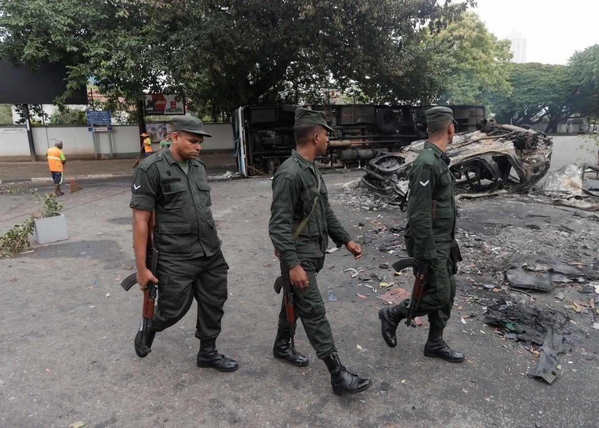 Military personnel patrol the area where vehicles were torched. Discarded files and smashed equipment littered the ransacked offices of government officials || Photo: Reuters