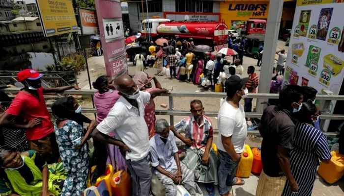People stand in a long queue to buy kerosene oil for kerosene cookers amid a shortage of domestic gas due to country's economic crisis, at a fuel station in Colombo, Sri Lanka March 21, 2022 || Reuters Photo: Collected 