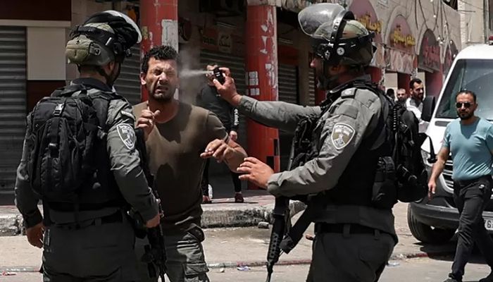 An Israeli border guard sprays pepper gas in the face of a Palestinian protester, during scuffles in the West Bank town of Huwara, on May 27, 2022 || AFP Photo