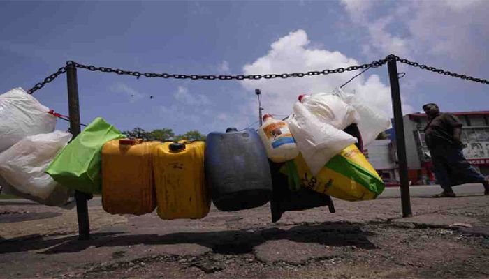 Empty vessels are tied up in a line to secure positions of a queue for buying kerosine oil outside a fuel station in Colombo, Sri Lanka, Sunday, June 5, 2022 || Photo: Collected 