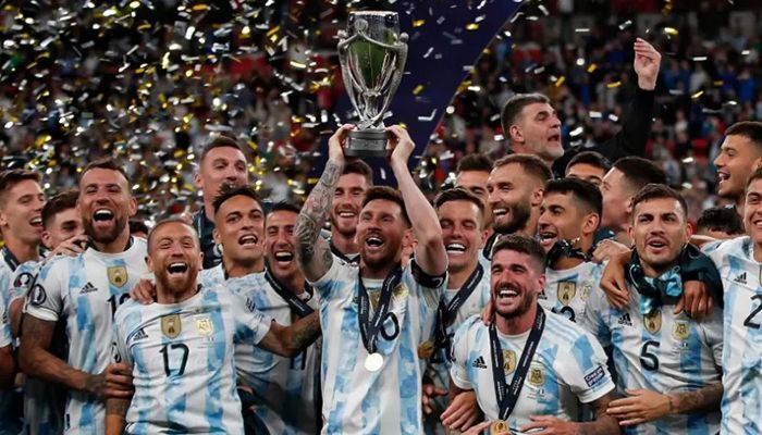 Argentina's striker Lionel Messi lifts the trophy as Argentina's players celebrate on the pitch after their victory in the 'Finalissima' International friendly football match between Italy and Argentina at Wembley Stadium in London on June 1, 2022 || AFP Photo: Collected  