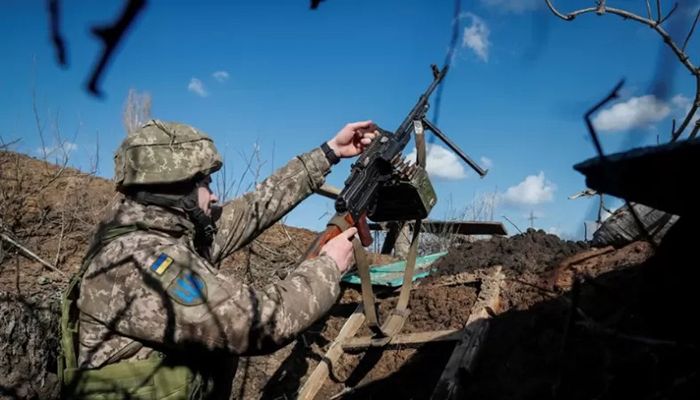 A Ukrainian service member holds a machine gun in a trench at a position on the front line near the village of Travneve in Donetsk region, Ukraine February 21, 2022 || Reuters Photo