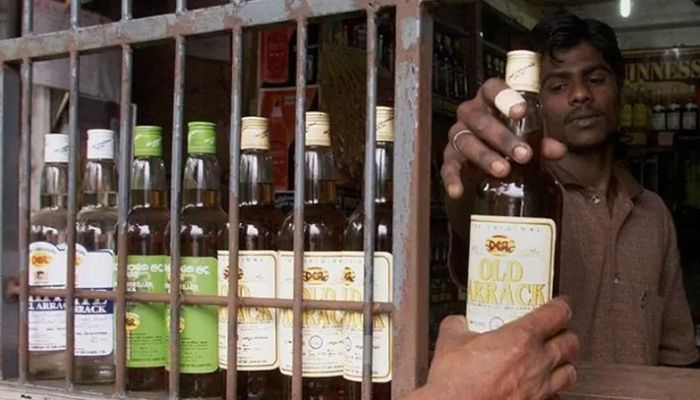 A Sri Lankan selling locally made arrack at a liquor shop in Colombo, Sri Lanka on October 23, 2002 || Reuters Photo: Collected  