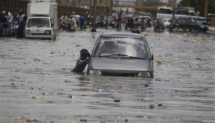 A car drives through a flooded road after a heavy rainfall in Karachi, Pakistan, Monday, July 11, 2022. || Photo: AP