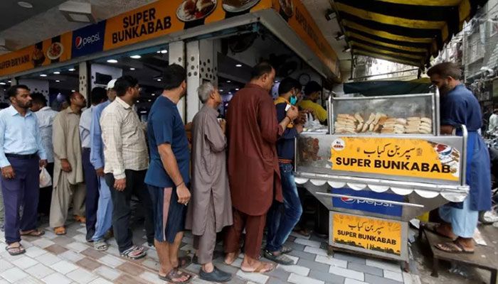 People wait for their turn to buy low-priced bun-kabab from a shop in Karachi, Pakistan June 10, 2022. || Reuters Photo