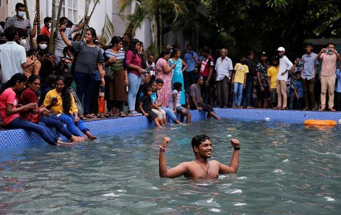 A man stands in the swimming pool as people visit the President's house on the day after demonstrators entered the building, after President Gotabaya Rajapaksa fled, amid the country's economic crisis, in Colombo, Sri Lanka July 10, 2022. || Photo: REUTERS