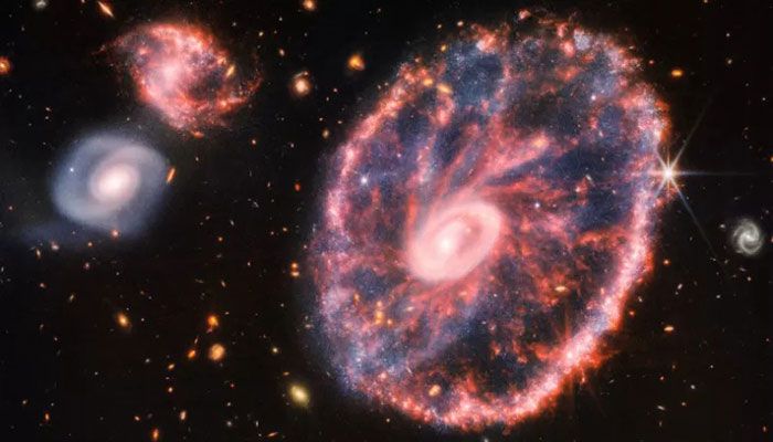 This handout composite image by ESA/Webb released on August 2, 2022 shows the Cartwheel and its companion galaxies is a composite from Webb’s Near-Infrared Camera (NIRCam) and Mid-Infrared Instrument (MIRI) || AFP Photo: Collected  