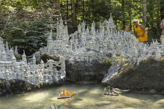 Swiss artist sculpts model castle on river bank