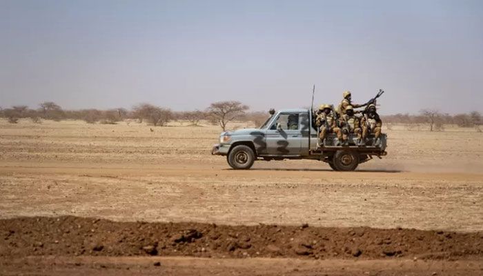 In this file photo taken on February 03, 2020 Burkina Faso soldiers patrol aboard a pick-up truck on the road from Dori to the Goudebo refugee camp. || AFP Photo
