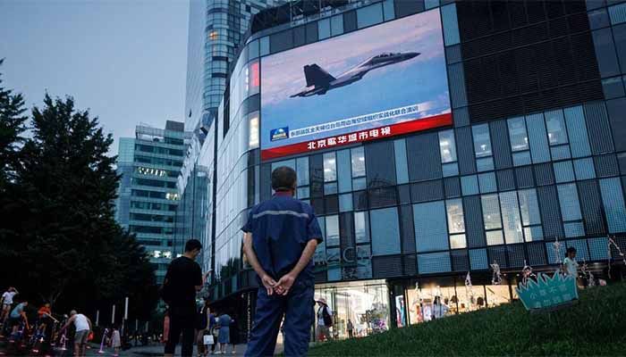 A man watches a CCTV news broadcast, showing a fighter jet during joint military operations near Taiwan by the Chinese People's Liberation Army's (PLA) Eastern Theatre Command, at a shopping centre in Beijing, China, August 3, 2022 || Photo: REUTERS
