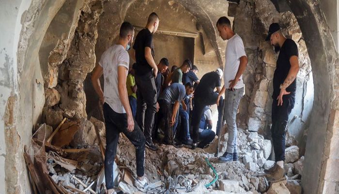 Palestinians inspect a building damaged during an Israeli military operation in Nablus on Tuesday || Photo: Collected 