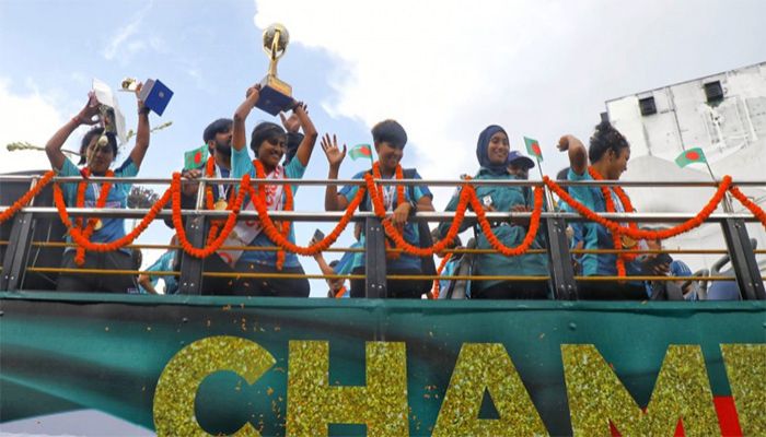 Bangladesh captain Sabina Khatun (2nd-L) holds the SAFF Women’s Championship trophy in an open-top bus on their way to the BFF House from the Hazrat Shahjalal International Airport on Wednesday || Photo: Collected 