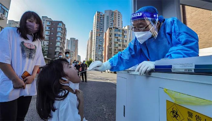 A health worker takes a swab sample from a child to be tested for the Covid-19 coronavirus in China's northern Tianjin on September 2, 2022. || AFP Photo