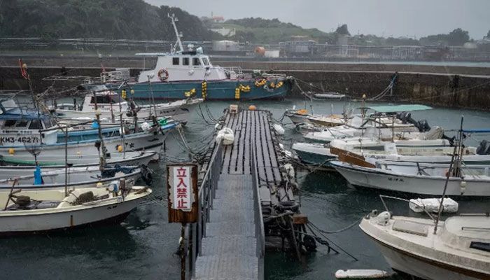 Fishing boats are seen moored as rain falls from weather patterns brought about by Typhoon Nanmadol at a port in Minamata, Kumamoto prefecture on September 18, 2022. || AFP Photo: Collected  