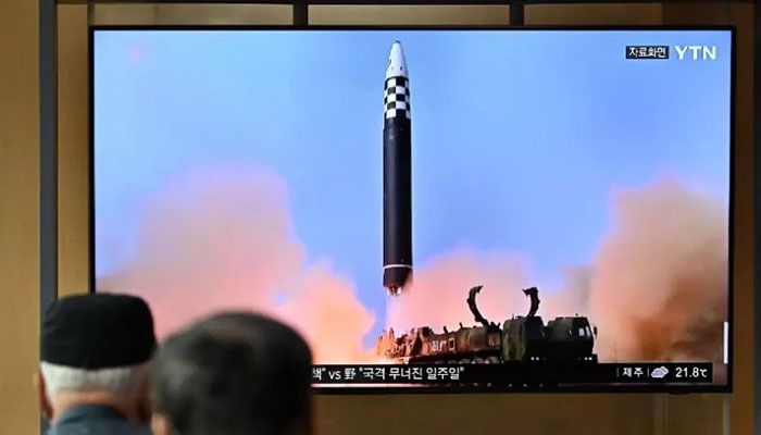 People watch a television screen showing a news broadcast with file footage of a North Korean missile test, at a railway station in Seoul on September 25, 2022. || AFP Photo