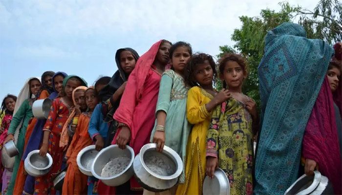 Displaced flood-affected people stand in a queue to receive food at a makeshift camp in flood-hit Sehwan, Pakistan. || AFP Photo: Collected  
