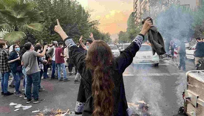 A woman takes off her hijab to protest the ongoing protests in Iran || Photo: Collected