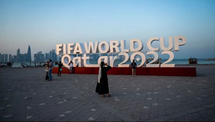 Visitors take photos with a FIFA World Cup sign in Doha on October 23, 2022, ahead of the Qatar 2022 FIFA World Cup football tournament || AFP Photo: Collected  