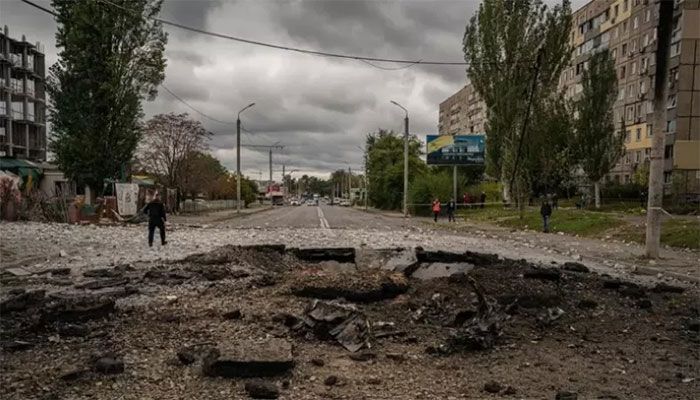 A policeman walks next to a crater following a missile strike in Dnipro on October 10, 2022, amid Russia’s invasion of Ukraine || AFP Photo: Collected 