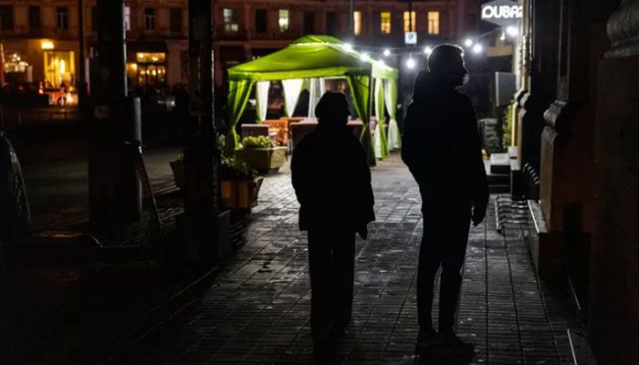 Pedestrians walk down a street during a power cut in downtown Kyiv on November 10, 2022 || AFP Photo: Collected  
