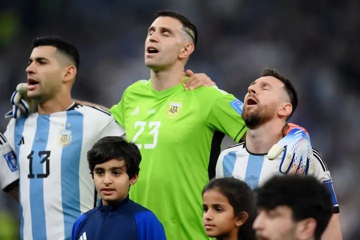 And there he is, singing his heart out during the national anthems with Cristian Romero and Emiliano Martínez || Photo: Getty Images