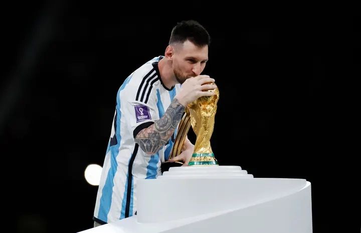 Messi kisses the trophy he’s chased for so long before being draped in a traditional bisht gown || Photo The Guardian