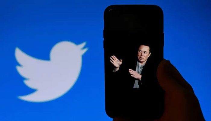 A phone screen displays a photo of Elon Musk with the Twitter logo shown in the background, in Washington, DC on October 4, 2022 || AFP Photo 