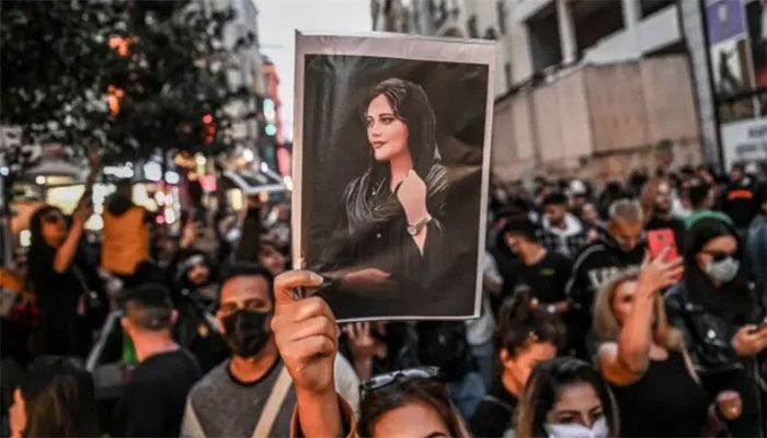 A protester holds a portrait of Mahsa Amini during a demonstration in support of Amini, a young Iranian woman who died after being arrested in Tehran by the Islamic Republic’s morality police, on Istiklal avenue in Istanbul on September 20, 2022 || AFP Photo