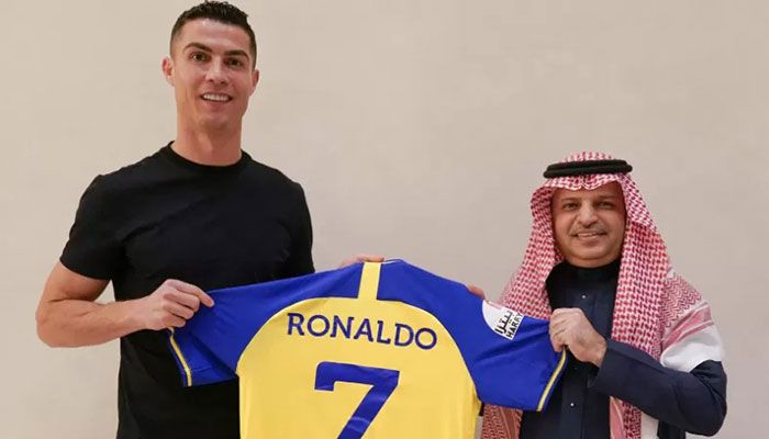 A handout picture released by Saudi Arabia's Al Nassr football club on their Twitter account shows Portugal's forward Cristiano Ronaldo being presented with the club's number seven jersey by club president Musalli Al-Muammar in Madrid on December 30, 2022, upon signing for the Saudi Arabian club || AFP Photo: Collected  