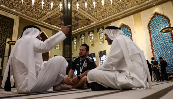 A football fan chats with Gulf residents inside Doha's Blue Mosque, during the Qatar 2022 World Cup football tournament, on November 29, 2022 || AFP Photo