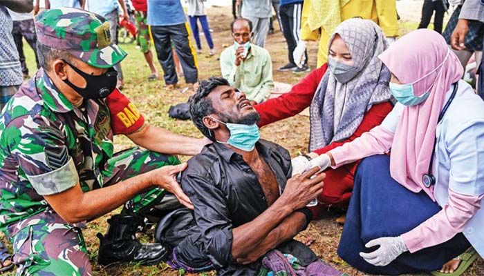 Health workers check a Rohingya refugee who was feeling sick after his arrival by boat in Krueng Raya, Indonesia’s Aceh province, yesterday || Photo: AFP