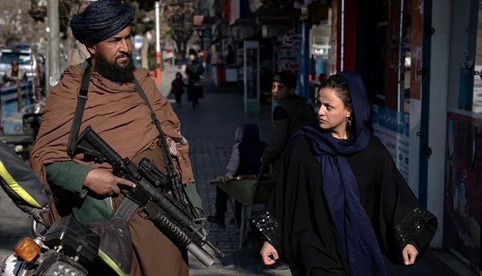 A Taliban fighter stands guard as a woman walks past him in Kabul. The UN announced this week that some ‘time-critical’ programmes in Afghanistan have temporarily stopped and warned many other activities will also likely need to be paused as a result of a ban by the Taliban-led administration on women aid workers. UN aid chief Martin Griffiths, the heads of UN agencies and several aid groups said in a joint statement that women’s ‘participation in aid delivery is not negotiable and must continue’, calling on authorities to reverse the decision || Photo: AP