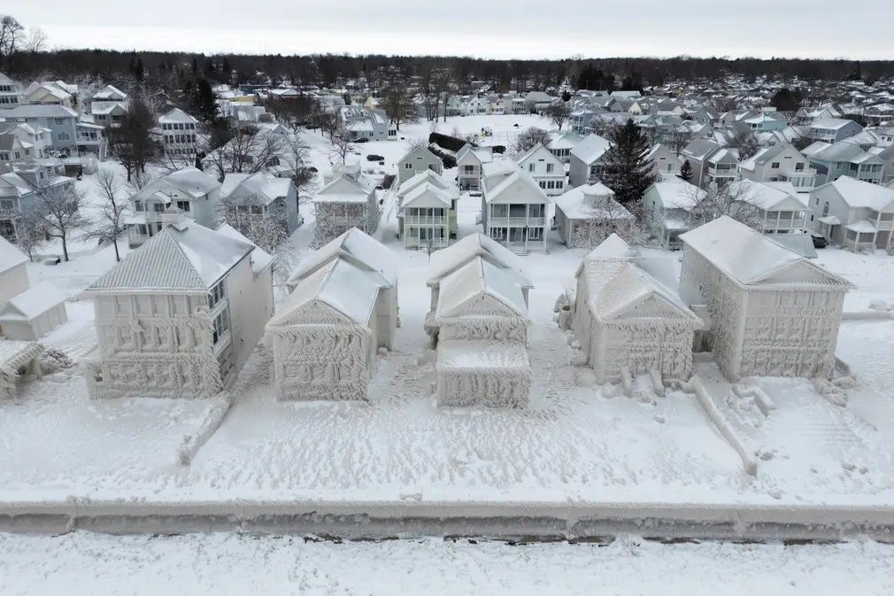 Houses along the shores of Lake Erie remain covered in ice following a winter storm that swept through much of Ontario || Photo: AP