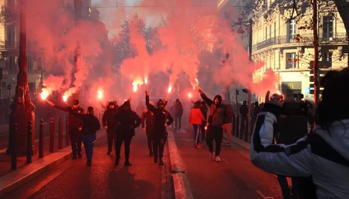 Protesters wave flares during a rally called by French trade unions against the government pension reform plan in Marseille, southern France. || AFP Photo 