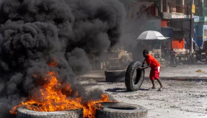 A protestor adds a tire to a burning barricade during a police demonstration to protest the recent killings of six police officers by armed gangs, in Port-au-Prince, Haiti, January 26, 2023. || AFP Photo