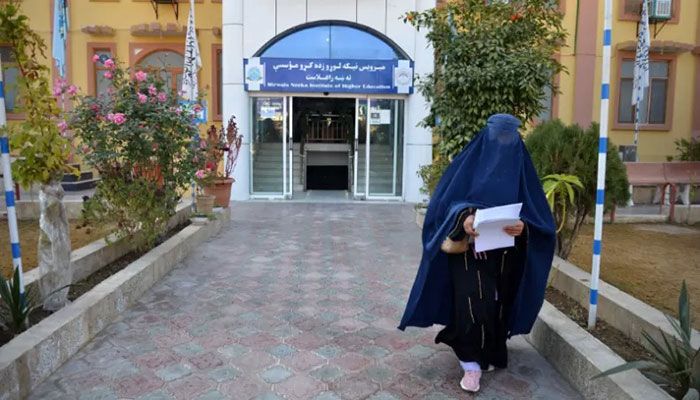 A female student walks in front of a university in Kandahar Province on December 21, 2022 || AFP Photo
