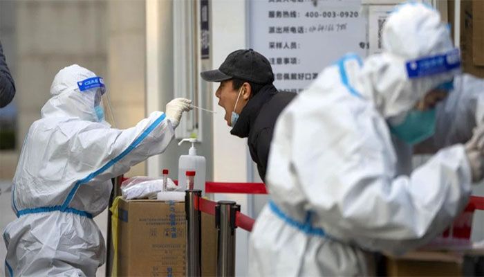 A worker wearing a protective suit swabs a man's throat for a COVID-19 test at a coronavirus testing site in Beijing on Nov. 17, 2022. || Photo: AP