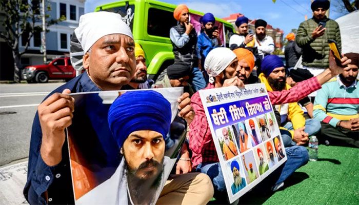 Raman Singh (L) holds a photo of Sikh organizer Amritpal Singh while protesting against the Indian government outside the Indian Consulate in San Francisco on March 20, 2023 || AFP Photo