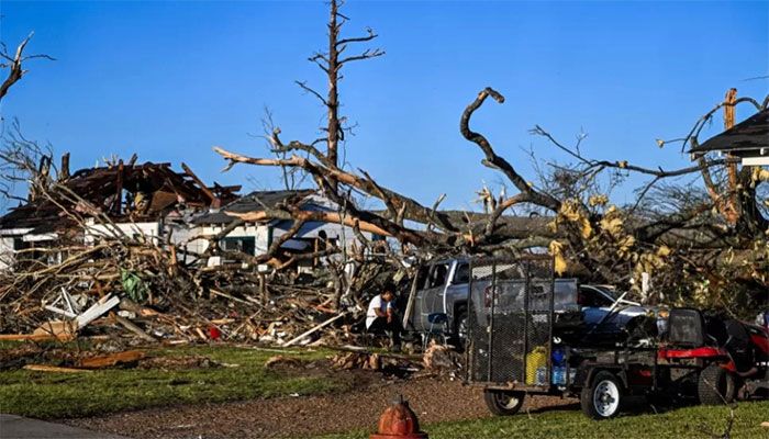 Ramona Brock sits outside the remains of a house and cars entangled in tree limbs in Rolling Fork, Mississippi, after a tornado touched down in the area March 25, 2023 ||  AFP Photo 