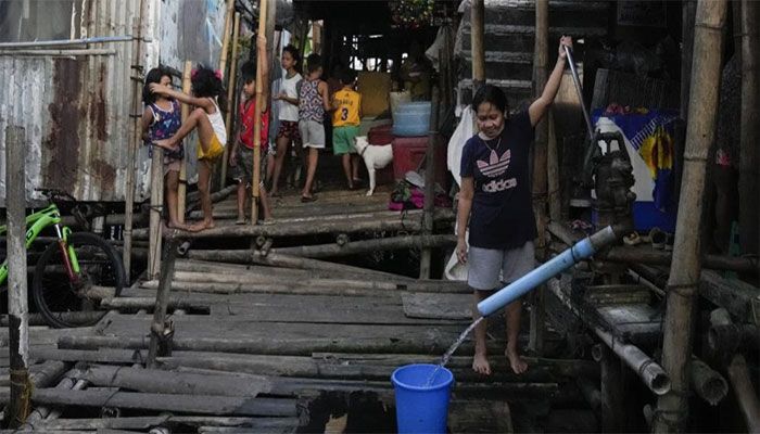 A woman uses a manual water pump at a slum area in Muntinlupa, Philippines on Tuesday, March 21, 2023. || AP Photo