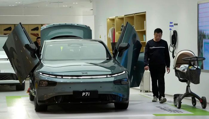 A visitor walks near the P7i electric sedan from Chinese automaker Xpeng at a showroom in Beijing, Thursday, April 13, 2023 || AP Photo: Collected  