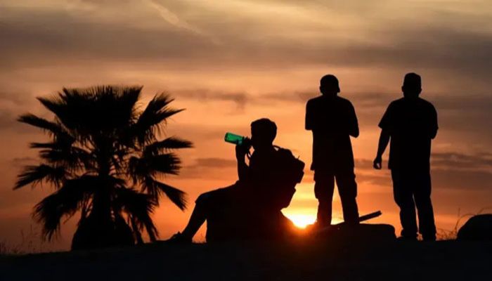 People view the sunset as a child drinks from a water bottle on June 15, 2021, in Los Angeles, California as temperatures soar in an early-season heatwave || AFP Photo: Collected  