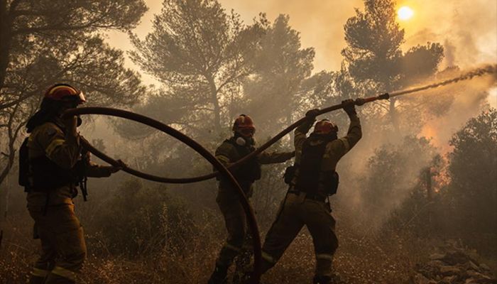 Firefighters battle a wildfire in Agia Sotira, a western suburb of Athens, Greece.
