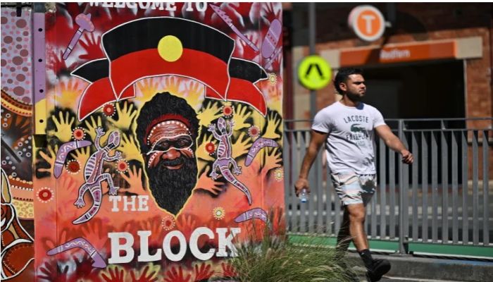 A man walks in front of Redfern train station in Sydney on October 14, 2023, as polls opened in Australia's historic Indigenous rights referendum. Photo: AFP