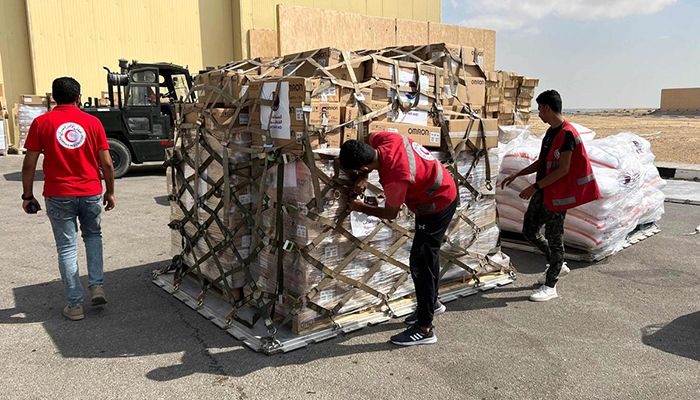 Volunteers from Qatar and Egypt’s Red Crescent humanitarian organisations check unloaded aid destined for the Palestinians of the Gaza Strip at Egypt’s el-Arish airport in the north Sinai peninsula on October 22, 2023 || Photo: Collected 