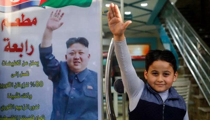 The son of Salam Rabaa, the Palestinian owner of Rabaa restaurant, gestures with his right hand imitating a poster of North Korean leader Kim Jong Un || Photo: Collected 