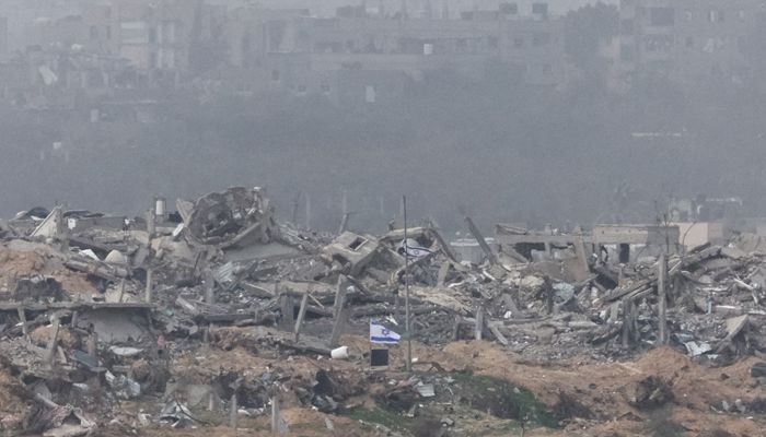 Israeli flags fly next to the rubble of destroyed buildings in Gaza || Photo: Reuters