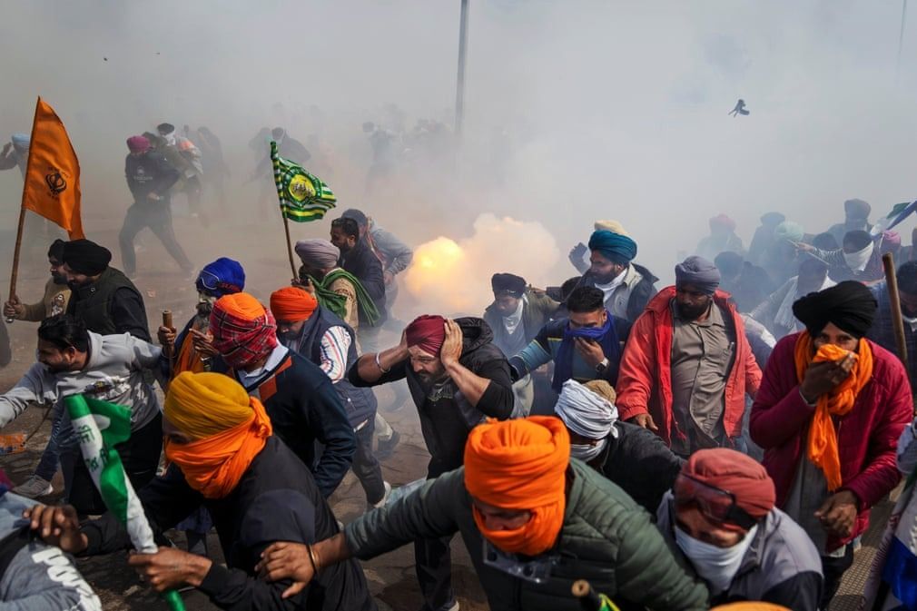 Shambhu, India: Protesting farmers run from exploding teargas shells used by the police near the Shambhu border that divides northern Punjab and Haryana. The farmers began their march to the Indian capital, New Delhi, last week, but have been blocked by the authorities || Photo: AP